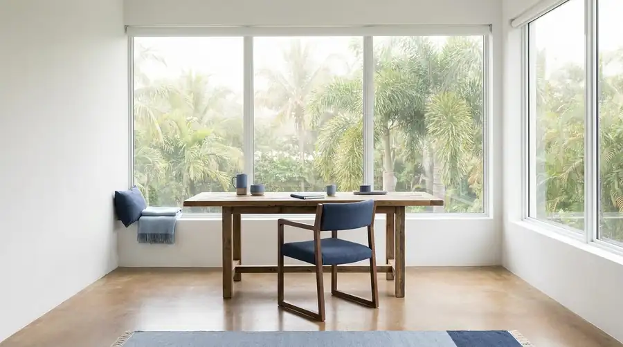 A quiet South Florida workspace with a wooden desk and palms beyond the window